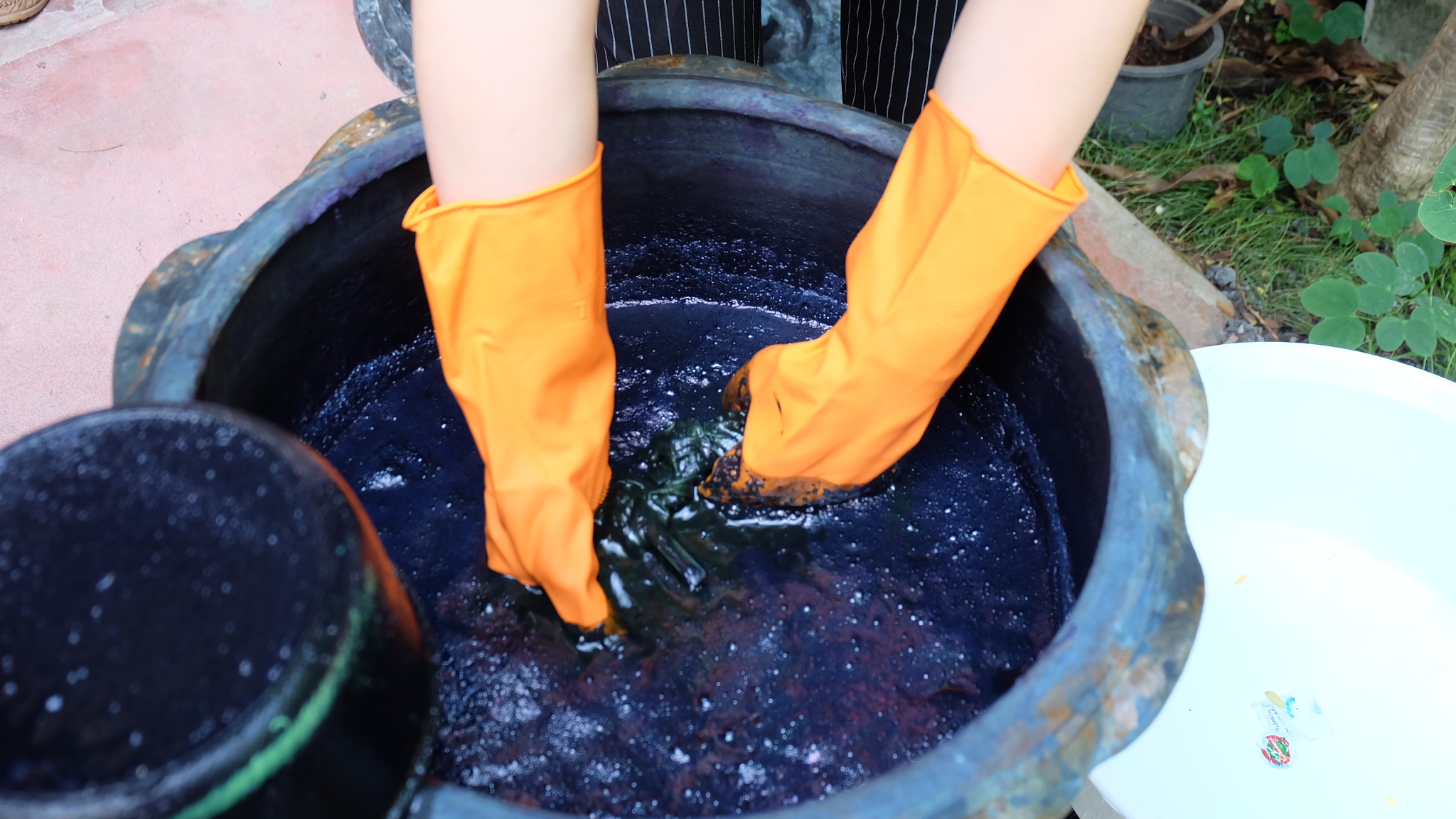 把扎好图案的棉布浸泡在木蓝叶浓汁内30-50秒