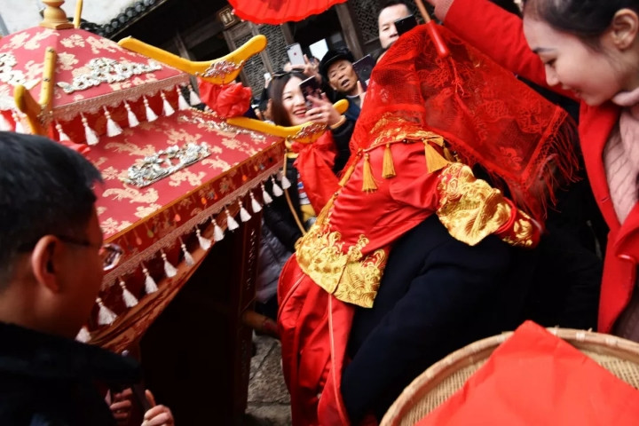 鞭炮齐鸣,锣鼓咚咚响,唢呐声声脆,新娘由父亲背上花轿,据说是新娘换上