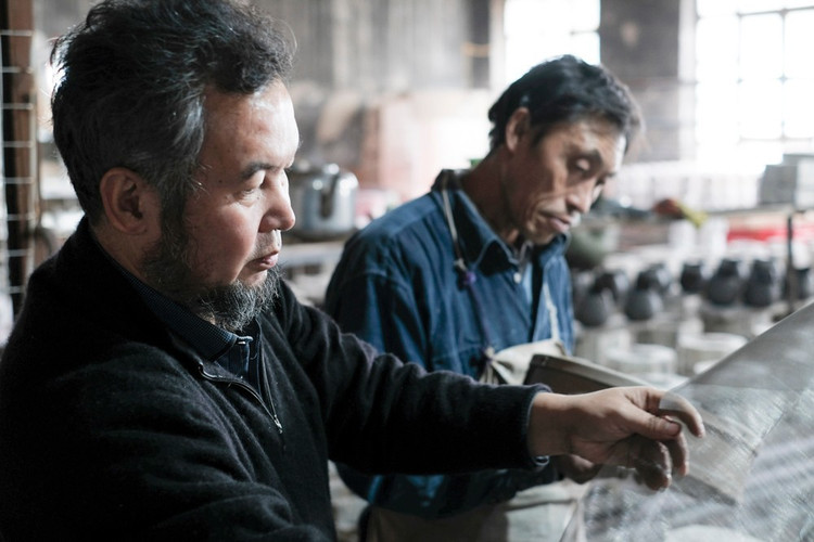 每一个细节都很重要,筛浆,除铁.图:姜成山和另外的老师傅在查看纱网.